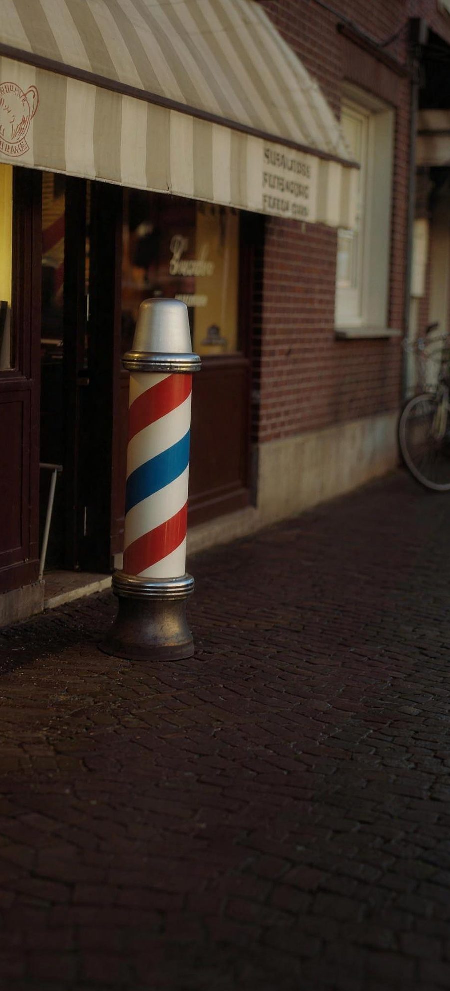 De barberpaal naast de deur van de salon in de Deldensestraat